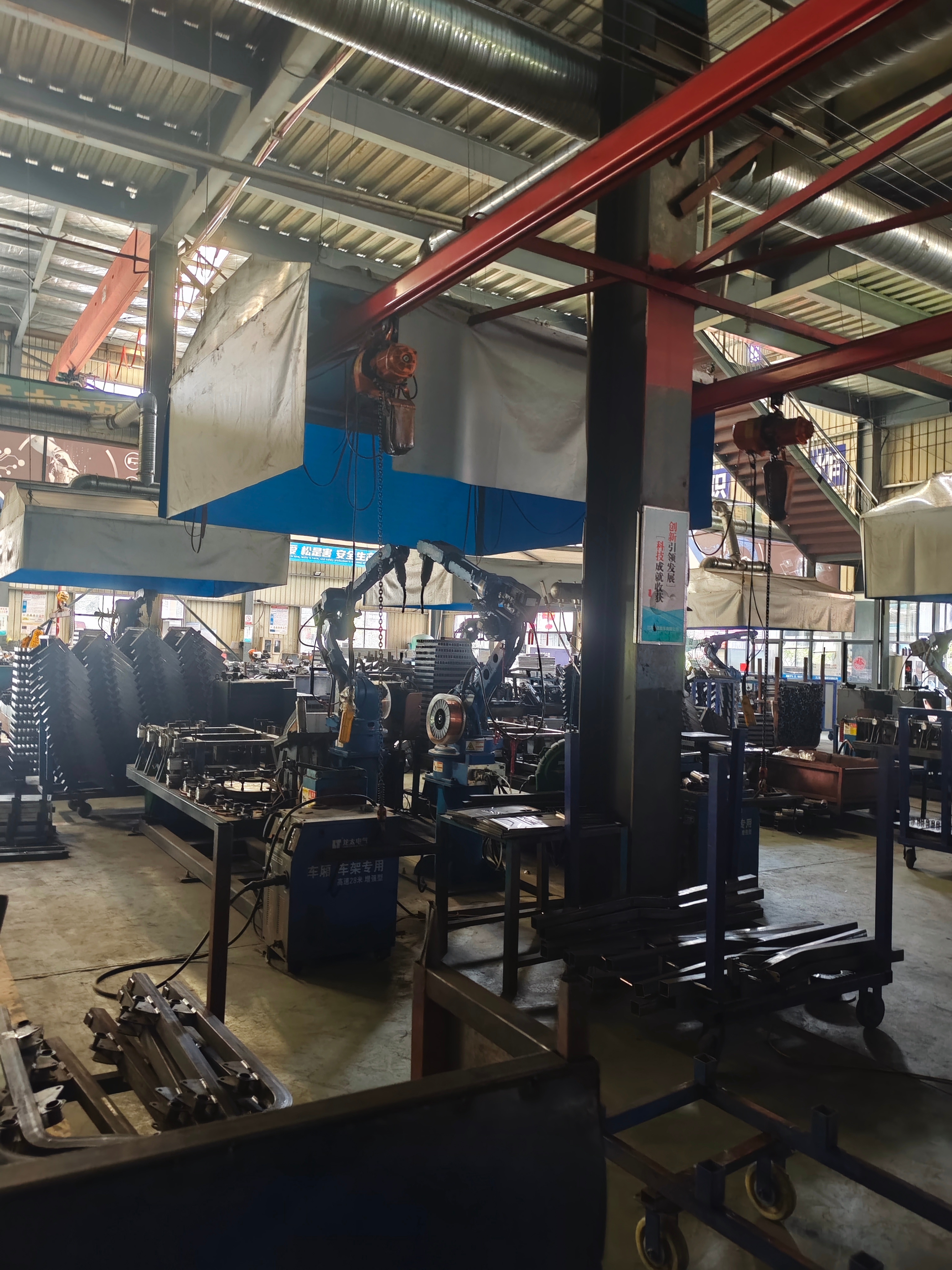 Industrial robotic welding equipment and steel fabrication fixtures on a mobility production floor